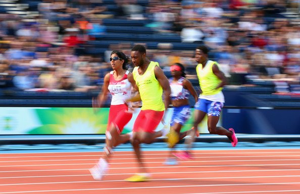 A picture of Selina Litt sprinting with a guide runner in the Glasgow 2014 Commonwealth Games.