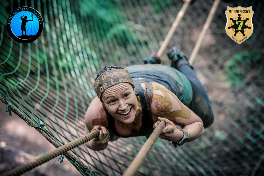 A picture of a lady on a rope obstacle during the Mudnificent 7 race.