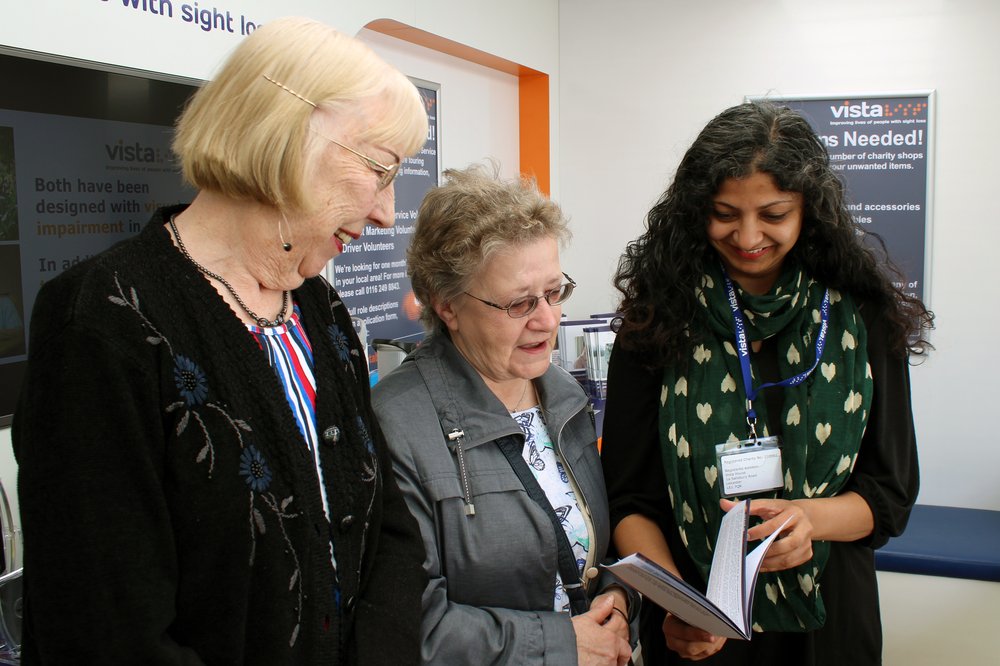 A picture of a Vista volunteer providing information to two ladies.