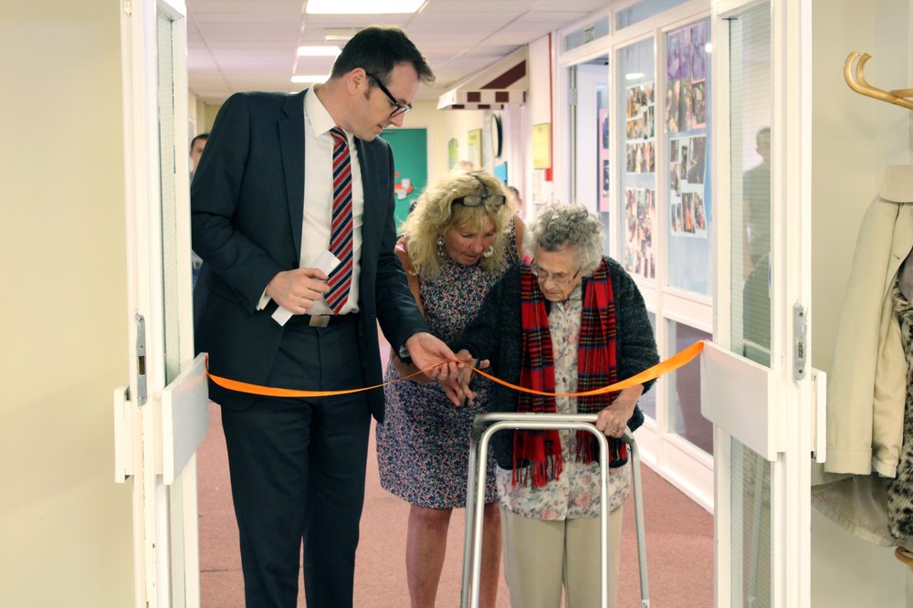 A picture of Paul Bott and Julie Rudd with a resident cutting the ribbon