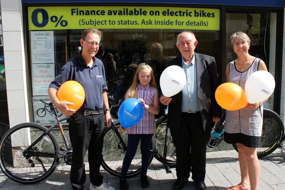 A picture of Liam, his dad Henry, granddaughter Rosie and Vista Fundraiser Louise outside the bike shop.