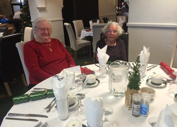 A picture of service users Barbara and Monica at a dining table.