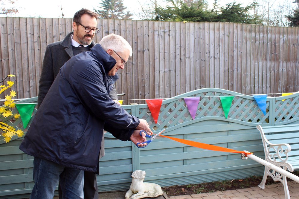 A picture of Chris Arrowsmith from Global Payments cutting the ribbon to open the sensory garden.
