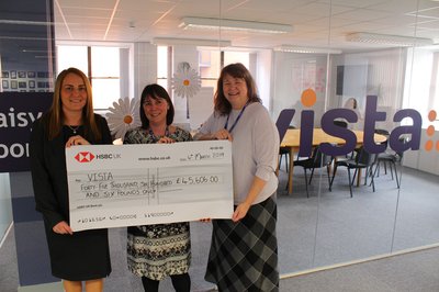 Vista CEO Susan and director of income generation with HSBC representative handing across the giant cheque