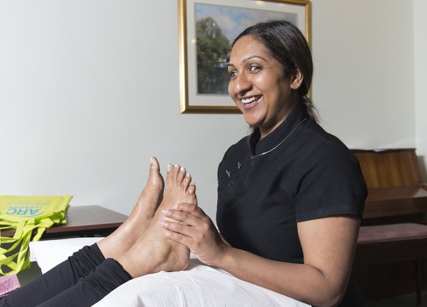 A picture of a lady giving a therapeutic foot massage.