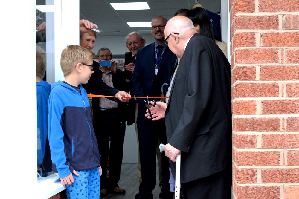A picture of a young boy and an older gentleman, supported by Vista, stood in front of the new Rothley shop.