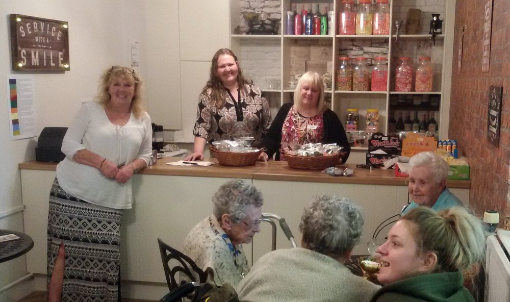 A picture of staff and residents at the new sweet shop.