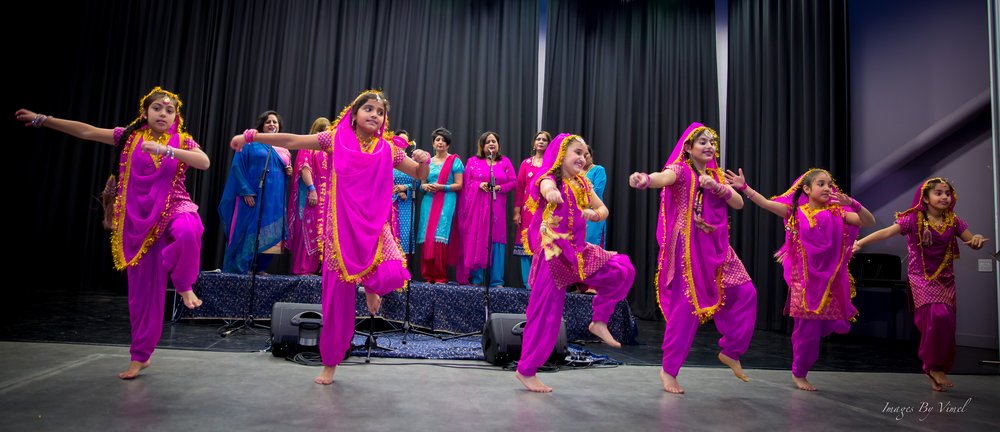 A picture of a group of dancing ladies in bright clothing.