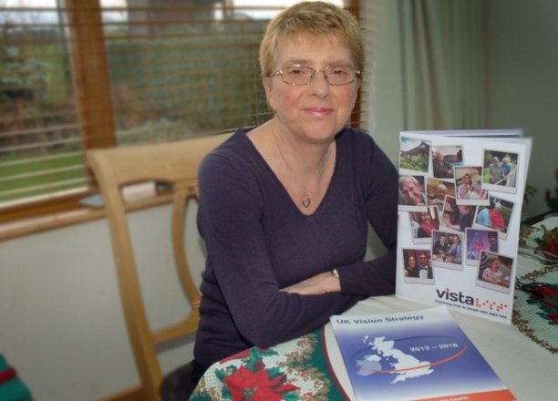 A picture of Jenny Pearce sat at a table with Vista and UK Vision Strategy literature.