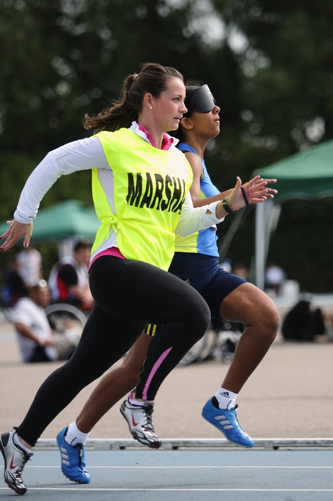 A portrait picture of Selina Litt running next to a guide runner.