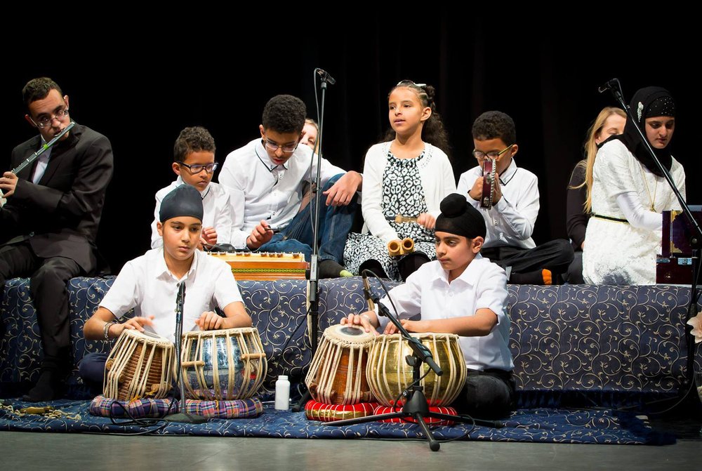 A picture of children and young people playing instruments on stage at the event.