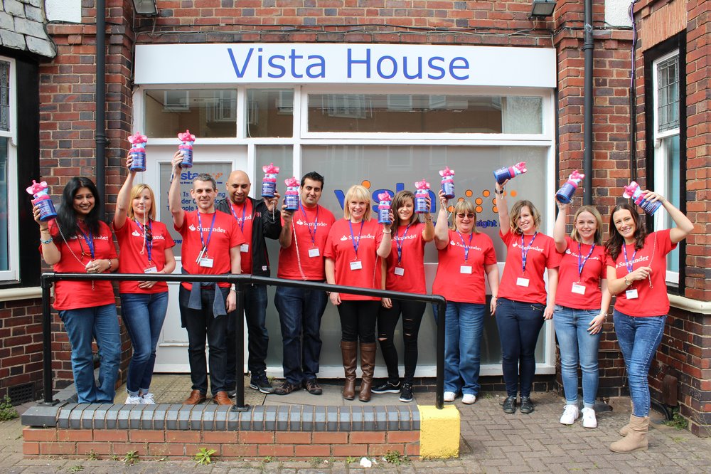 A picture of Santander staff holding Vista collection boxes outside Vista House.