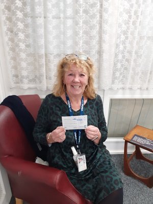Residential Care Home Manager, Julie Rudd  holding a card to say she has been nominated for the Leicestershire Care Professional of the Year Awards.