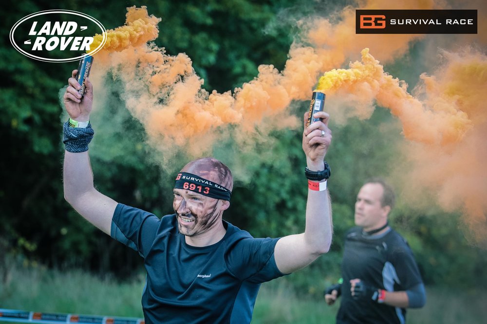 A picture of a man running with smoke grenades.