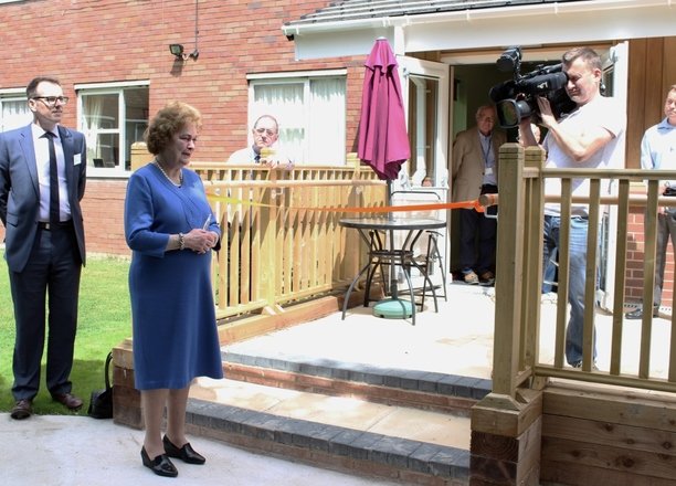 A picture of the Dowager Duchess cutting an orange ribbon in front of the Butterfly Lounge.