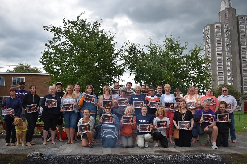 Image is of everyone who took part in Vista's firewalk holding their certificates up and smiling at Loughborough University, Shirley Pearce Square.