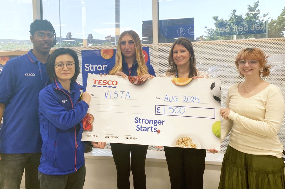Jemima, Vista's Community & Events Fundraising Manager, stands with another member of the Vista Team and three colleagues from TESCO holding a cheque for £1,500.