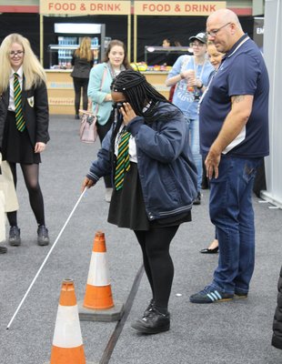 A student with a cane trying to navigate an obstacle course
