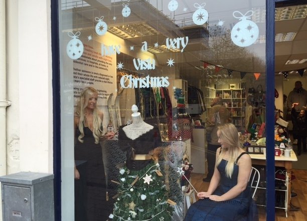 A picture of a volunteer posing as a mannequin in the Loughborough charity shop window.