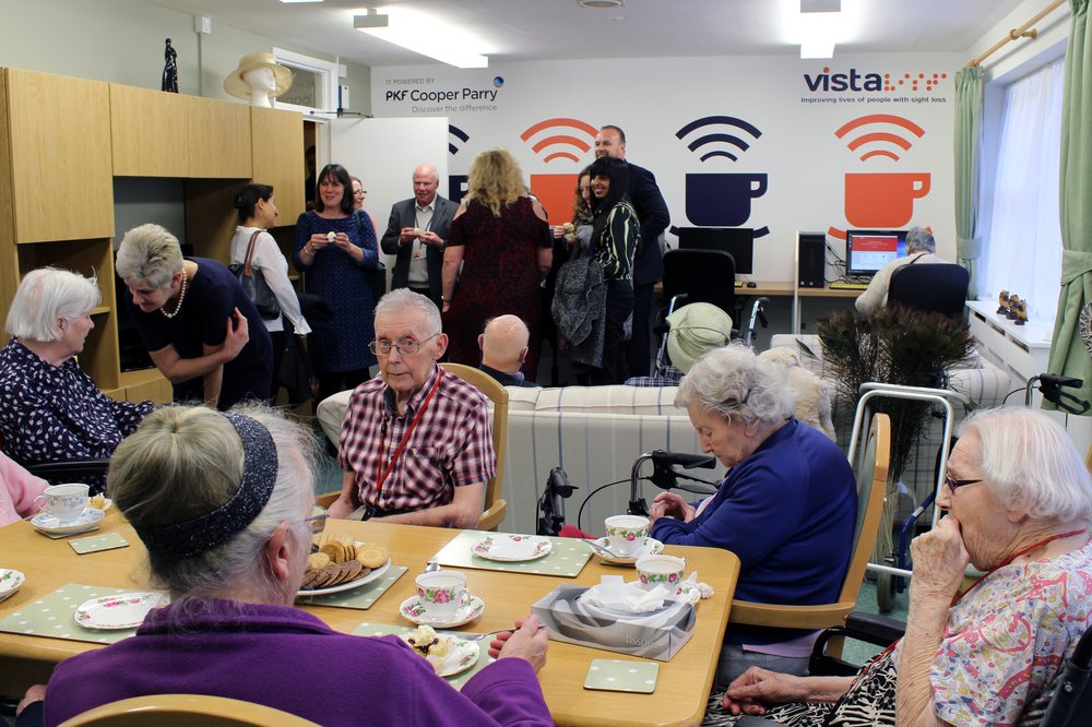 A picture of residents and staff members at the opening ceremony of the Cyber Cafe.