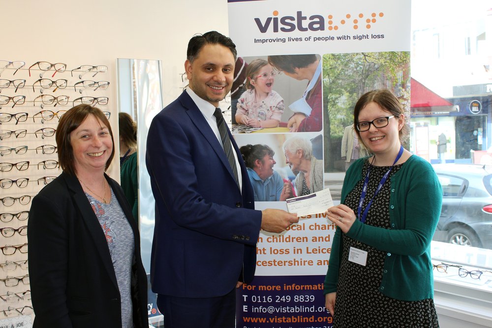 A picture of an Optician providing a cheque to Vista's Community and Corporate Fundraiser.