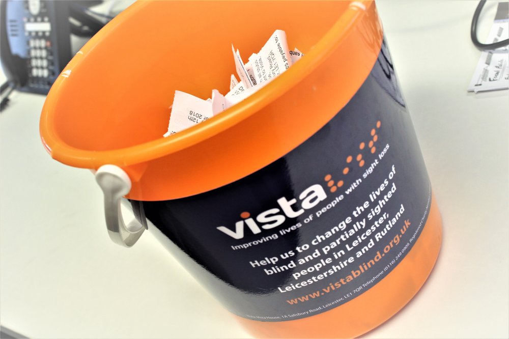 Image is of a Vista branded bucket with raffle tickets poking out the top of it.