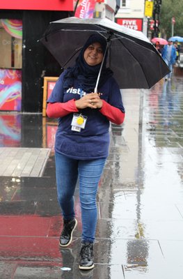 Ray with an umbrella in the rain, smiling