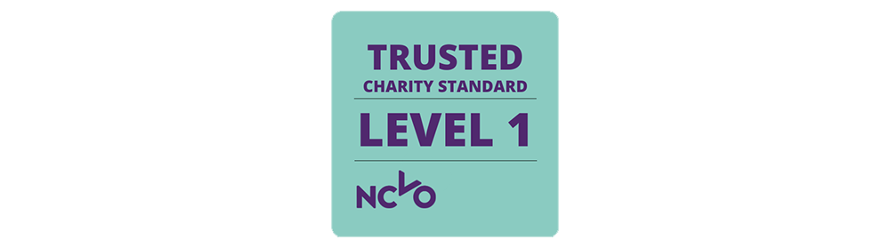[Image Description: Trusted Charity Standard Level One NCVO logo. Purple text on a blueish-green background.]