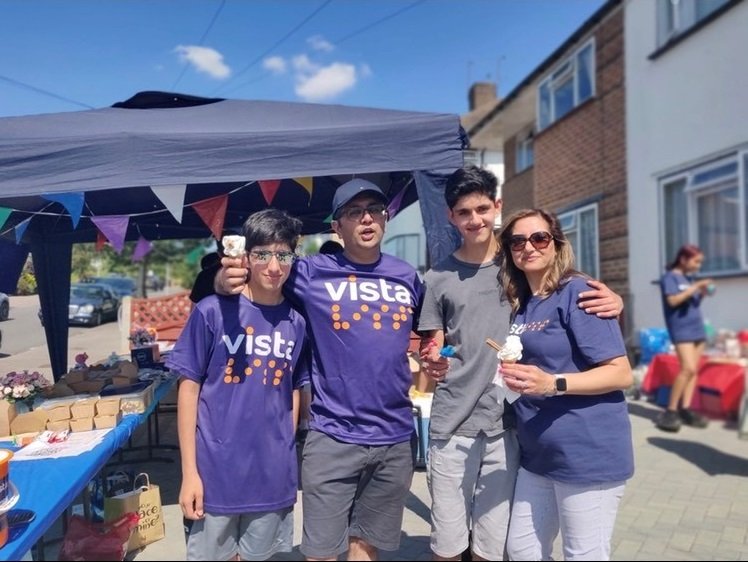 Image is of the Borkhatria family wearing Vista t-shirts. They are smiling and holding ice-creams.