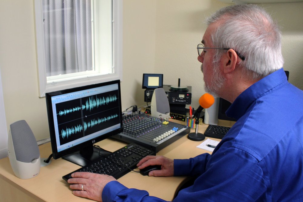 A picture of a volunteer editing a recording on the computer in Vista's studio.