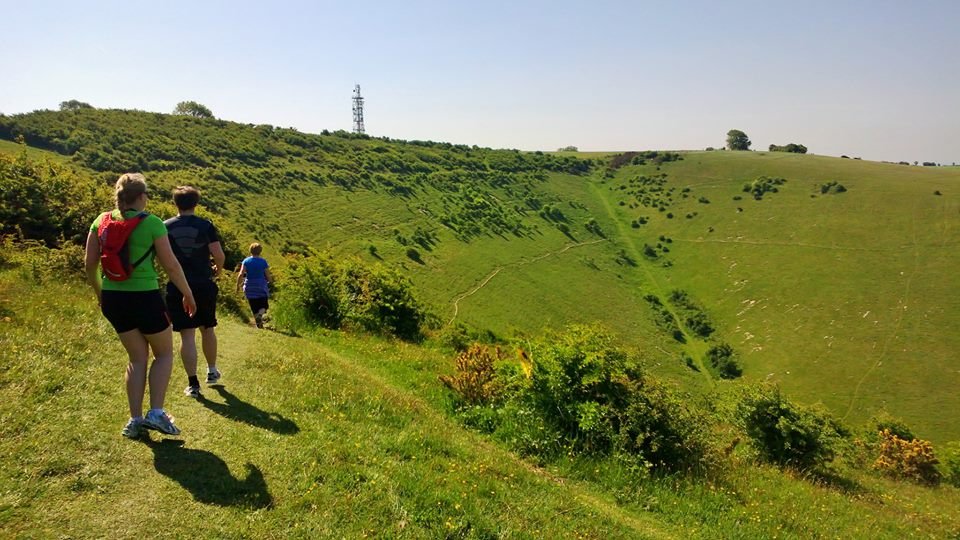 A picture of people running over the scenic South Downs hills.