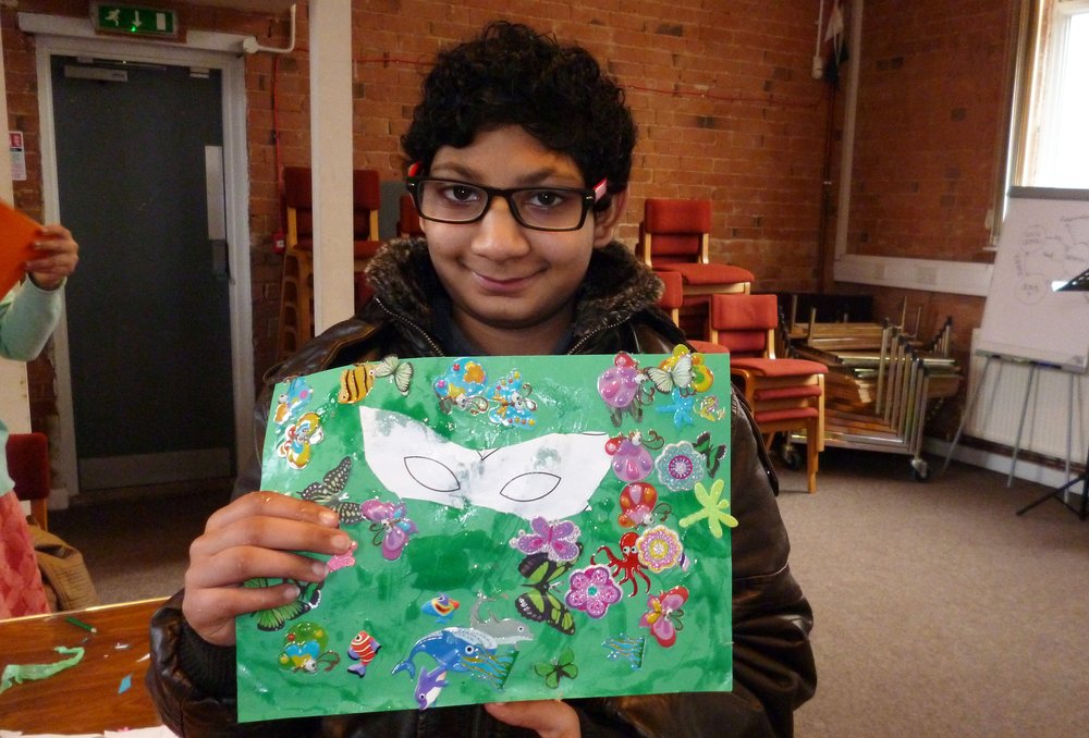 A picture of Vihan holding a piece of artwork he made at one of Vista's youth clubs.