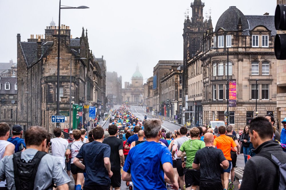 A crowd of people running in the Edinburgh Marathon Festival.
