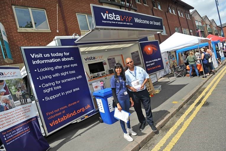 A picture of two Vista staff in front of the Mobile Support Service vehicle.